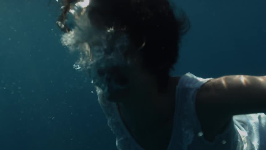 A woman is swimming under the water
