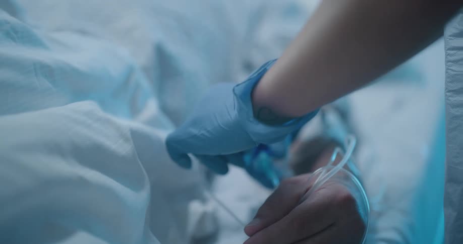 A nurse connecting an iv to a patient in a hospital bed