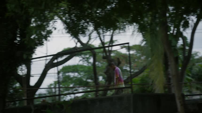 A man is skateboarding and doing jumps behind a fence up high