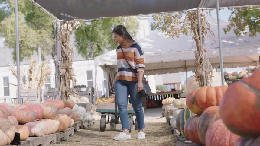 A woman looking at pumpkins