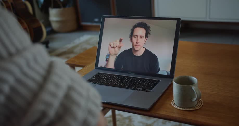 Two friends talking on a video call on a laptop at home