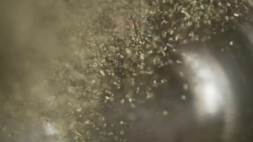 Powdered dried oregano flipping inside a metallic bowl