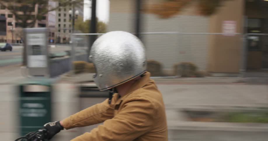A person rides a motorcycle down a street in a city