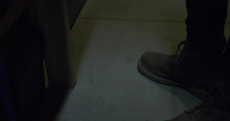 Man cutting a piece of metal with a power tool in a workshop
