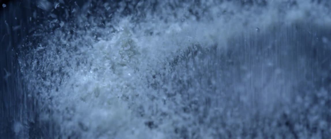 White crystalline powder shakes on vibrating gray surface