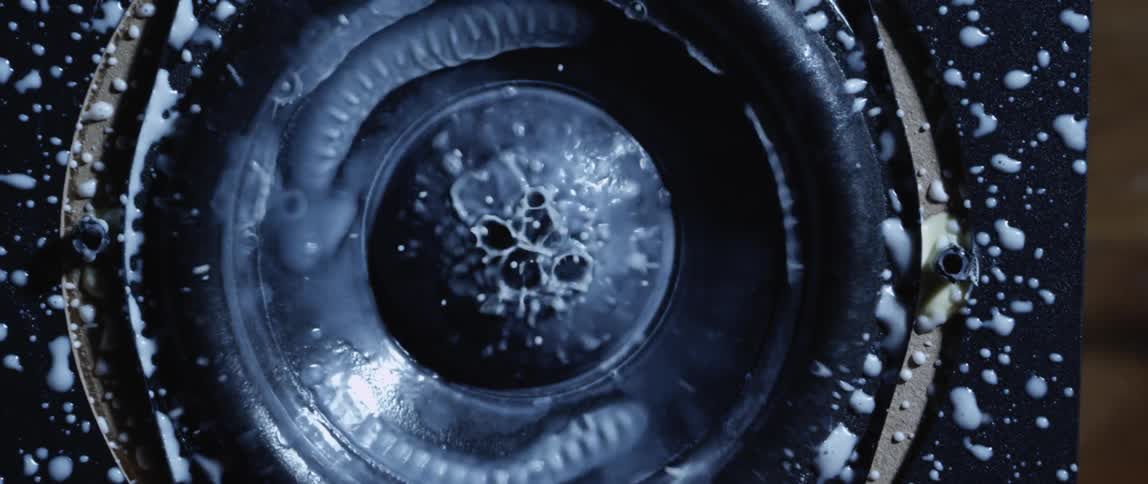 White liquid in a centrifuge splashes up and out as the centrifuge starts moving