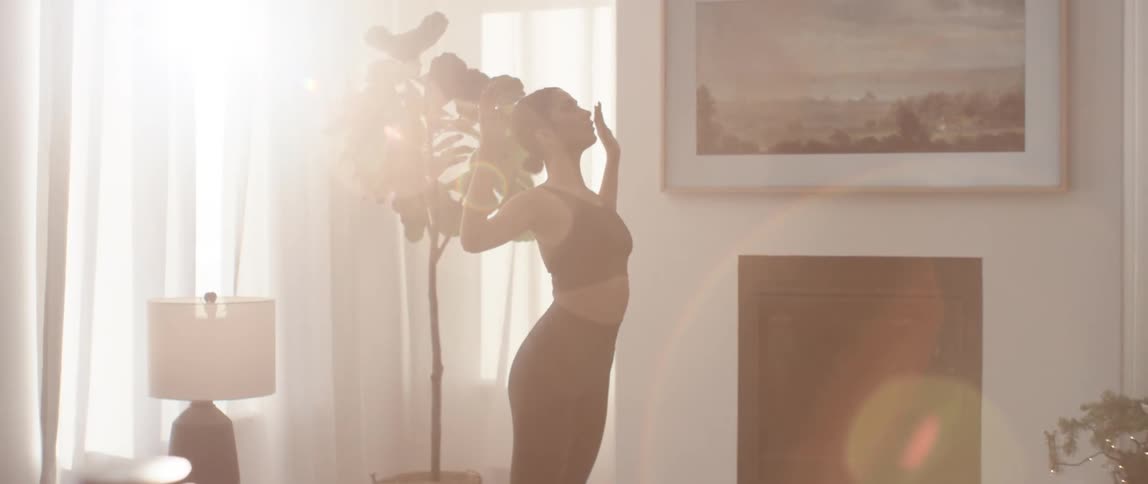 A woman exercising at home in the living room during the day