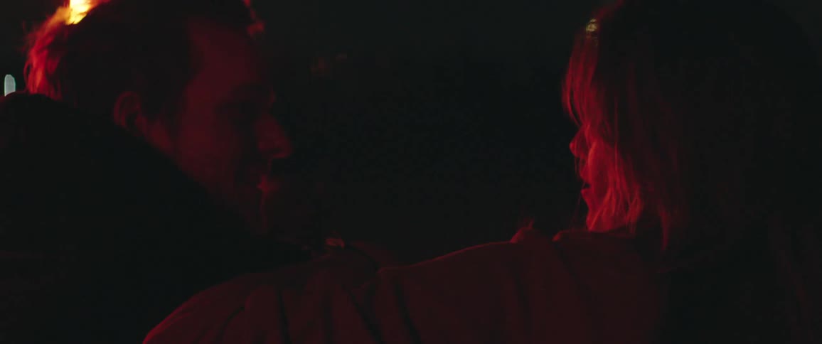 A man and woman are outdoors at night