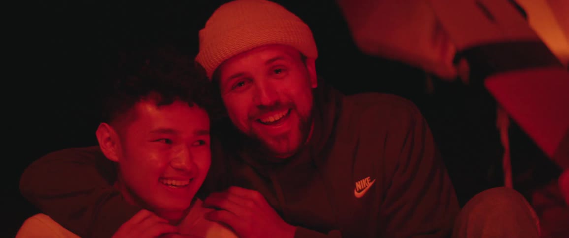 Two men are outdoors at night