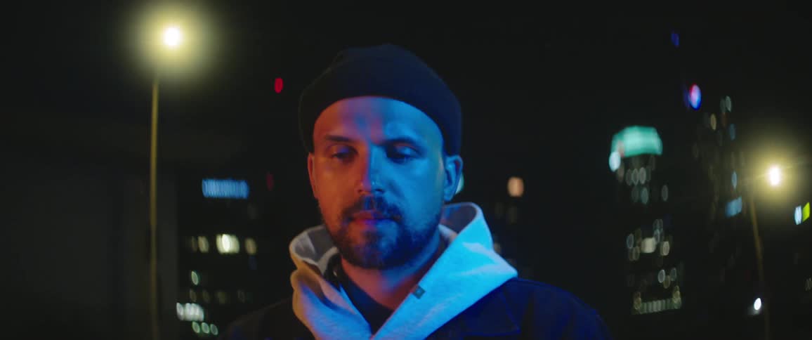 A man standing on a city street at night