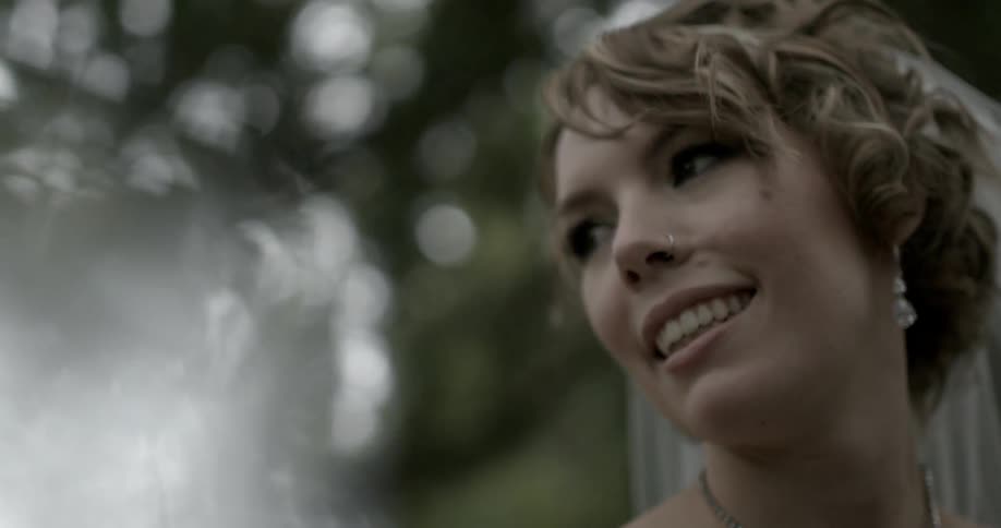 A woman is smiling as she looks to the side