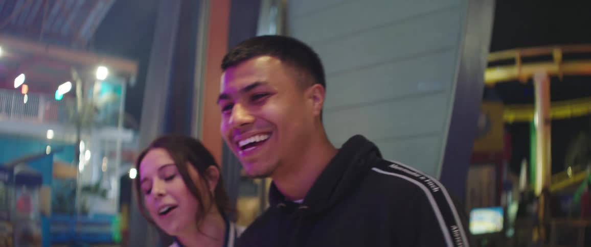 Young couple having fun in a game stall on an amusement park at night