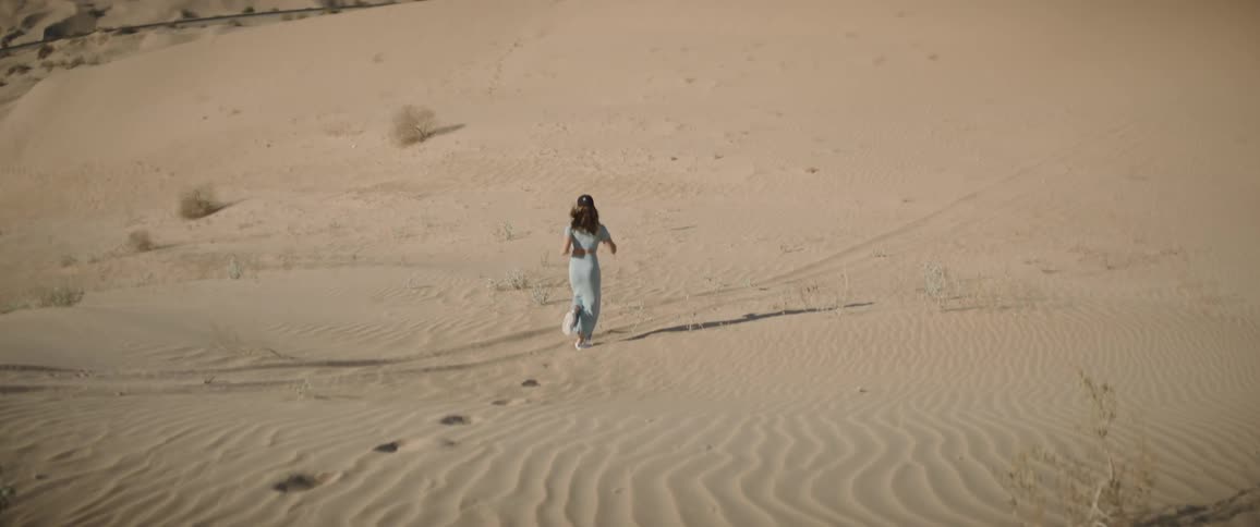A woman is jogging through the desert
