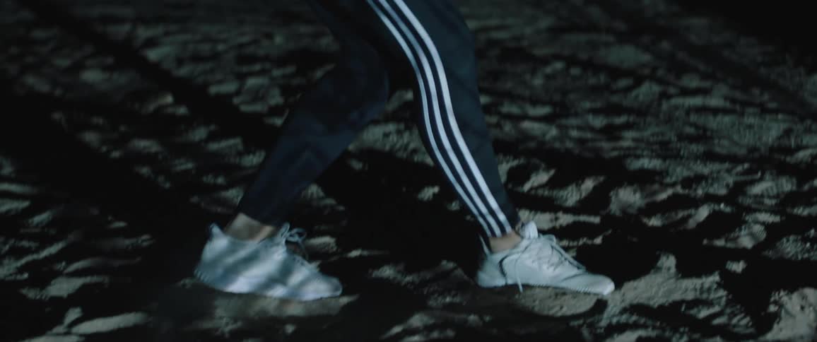 A person walking backwards on a beach