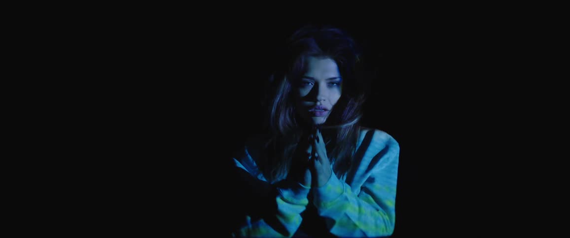 A woman is standing outdoors at night