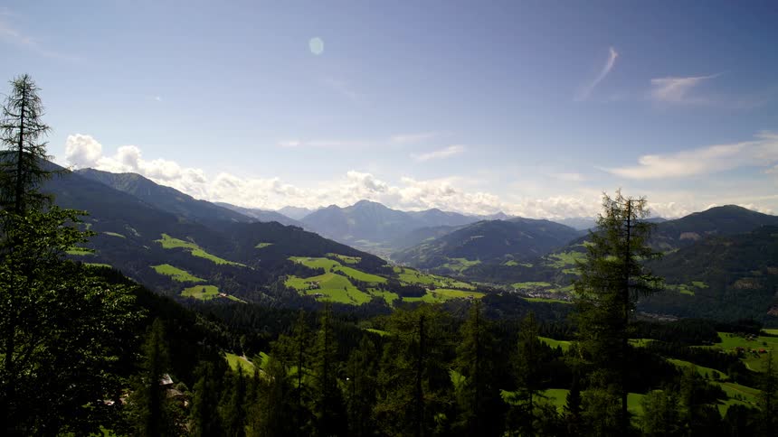 Mountain range with trees in front and clouds rolling by