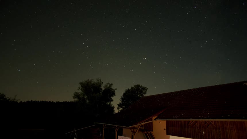 A house with trees the sky and stars in the background