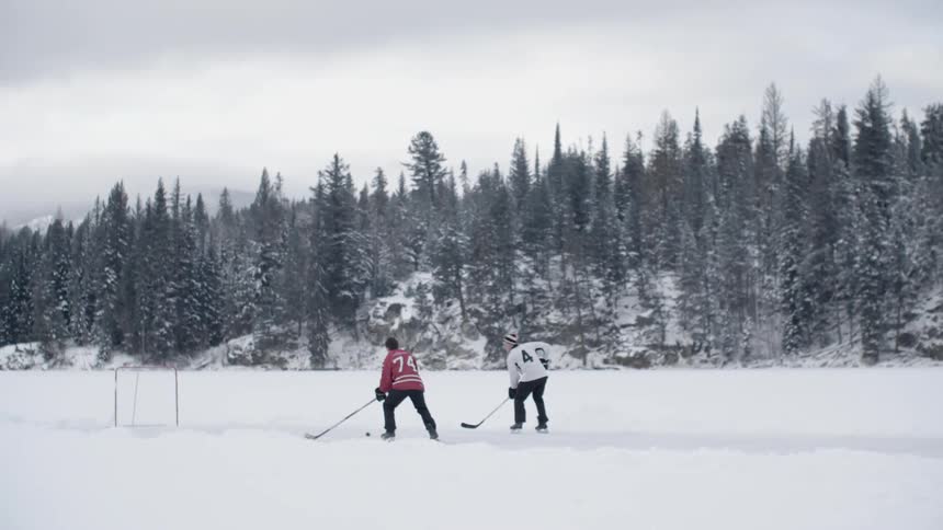 People are skating along the ice playing hockey