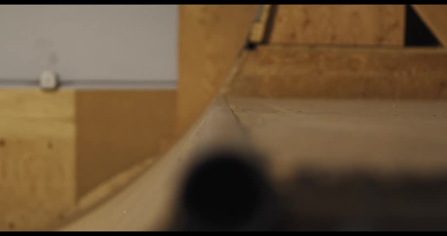 A person rides a rail on a ramp with a skateboard
