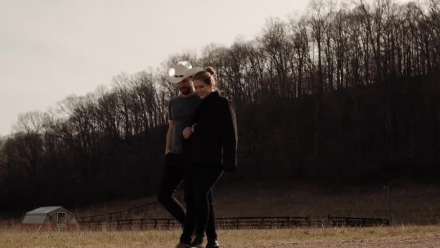 A man and woman are walking together in a rural area
