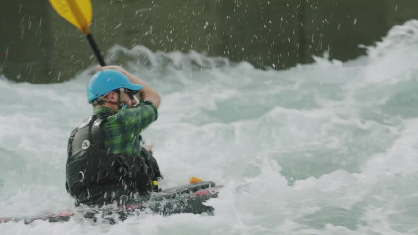 A man is kayaking down a river