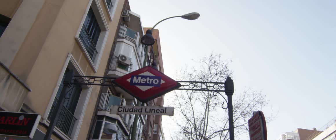 Just below an apartment building a sign for the metro subway is posted