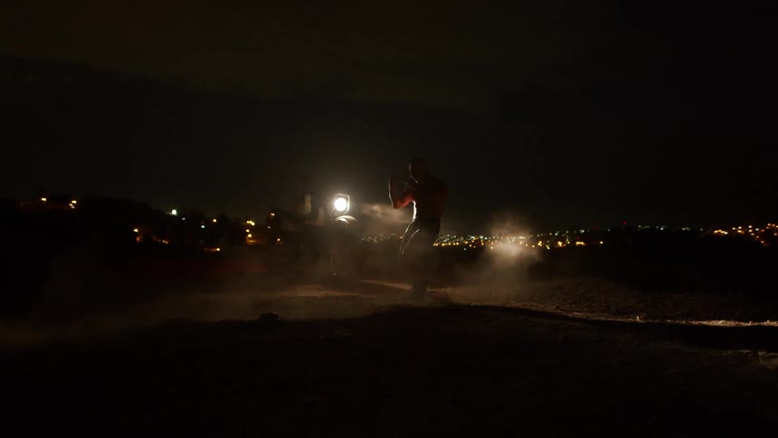 A man is boxing outdoors at night