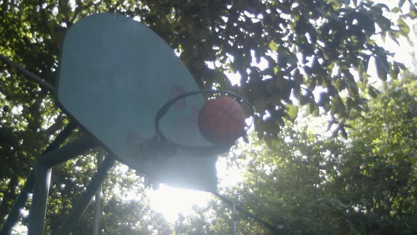 A person is playing basketball during the day