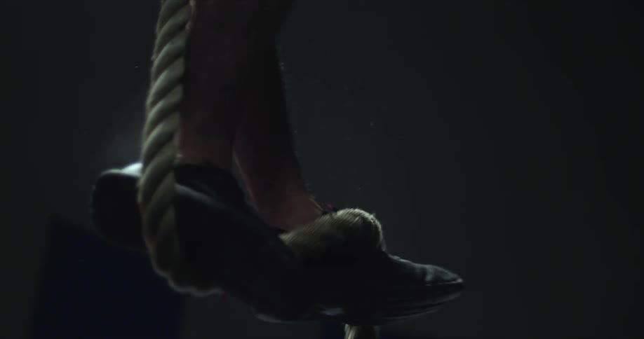 Man legs climbing down a gym rope