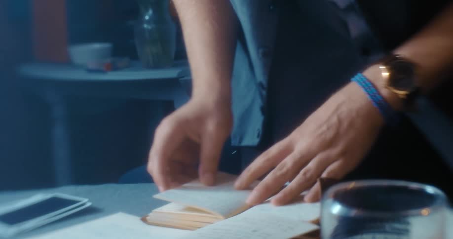 A man is in a house and looking at a notebook
