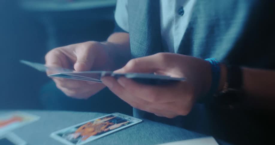 A man is sitting at the table playing cards