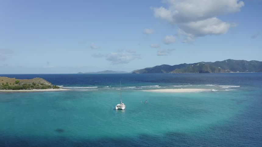 A boat sits in a body of water with land visible