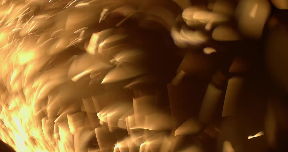 Out of focus footage of a shower of yellow sparks in a dark background