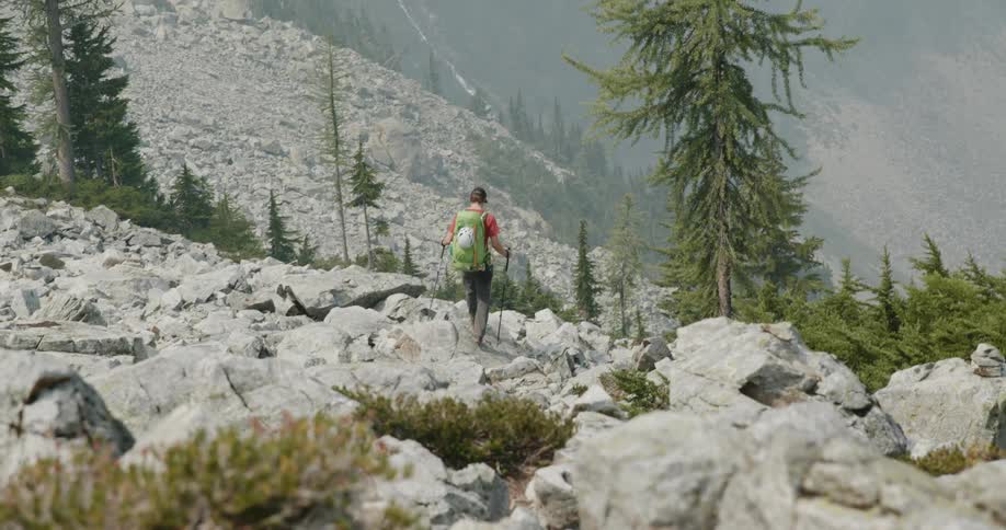 A man is hiking through a mountain area
