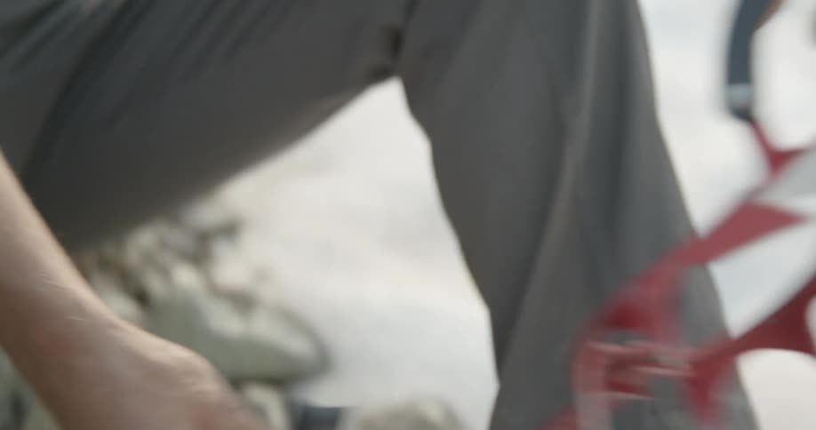 A man unfolds an ice cleat in order to place it onto the bottom of his boot for walking in the snow