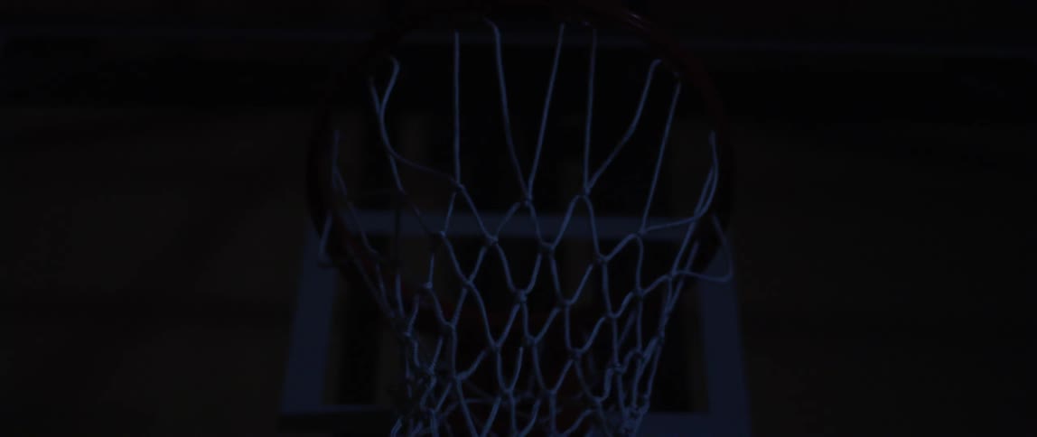 A basketball going through a basketball hoop and net