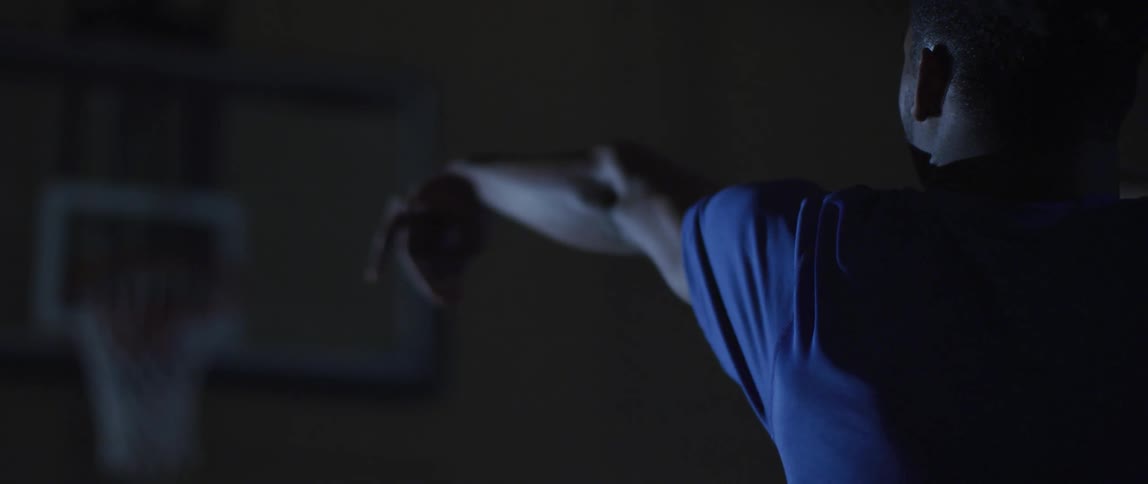 A young basketball athlete misses a shot into the basket