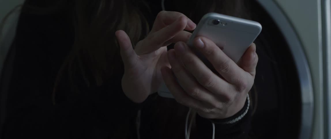 A man holds a large smart phone in one hand at touches the screen with the other