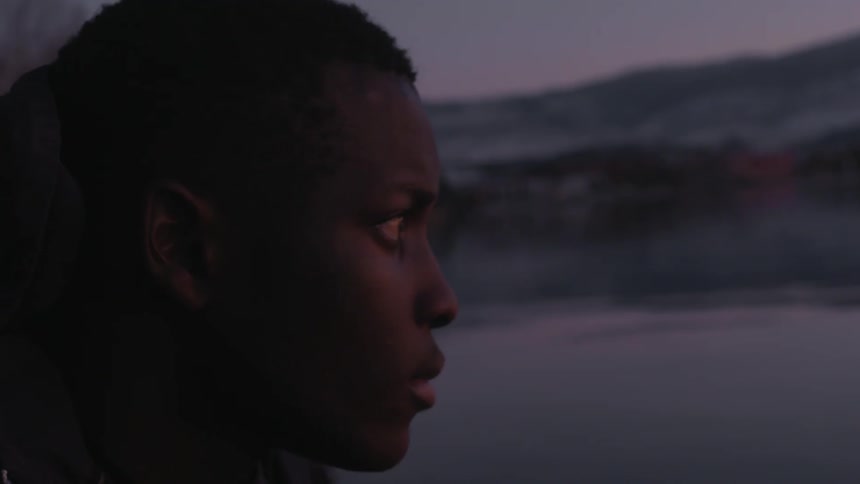 A man looks out at a lake
