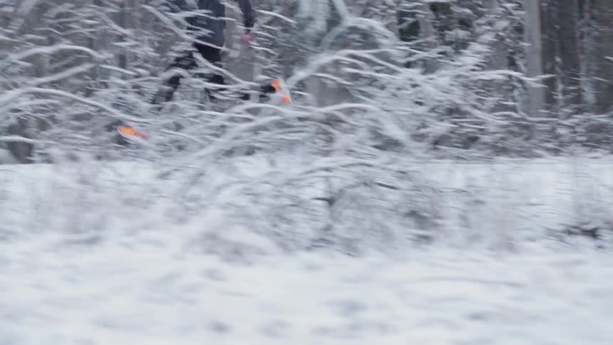 Man running very fast through a snow covered forest