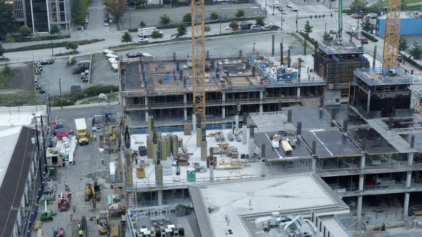 Aerial view of two buildings under construction as contractors work on site