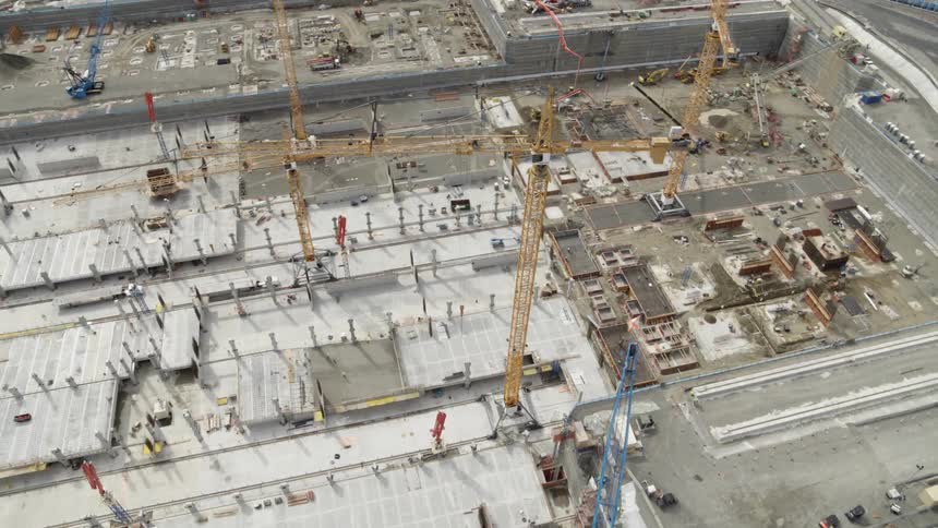 Orbiting around multiple cranes operating within a massive construction site