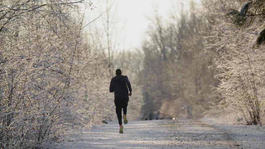 Man running down a snow covered dirt road