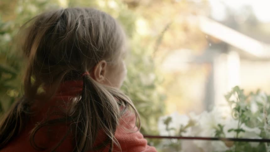 A girl seeing outside from the balcony