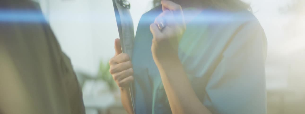Female nurse wearing blue scrubs in a hospital talking in front of a sunlight flare