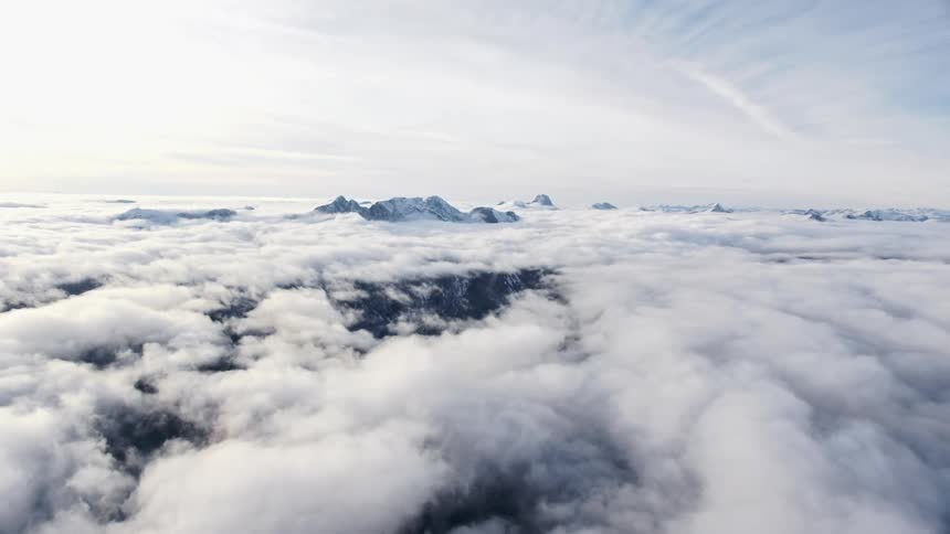 Mountain range with peaks high above the clouds on a cloudy day