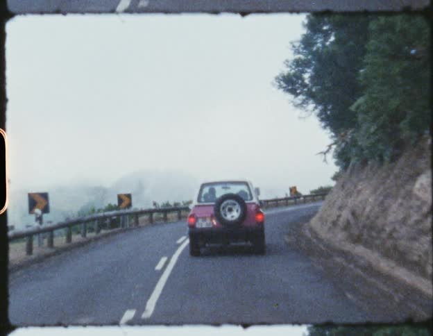 Car driving along a road on the side of a hill