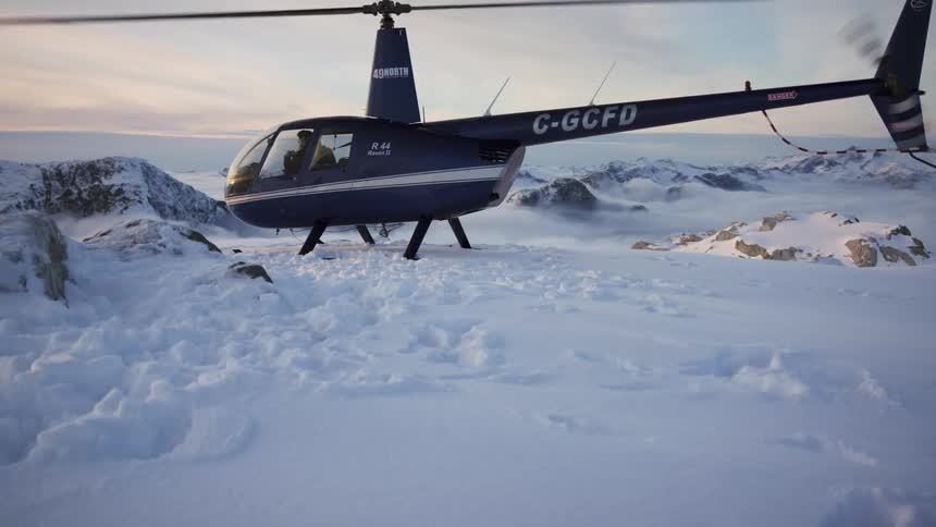 Footprints in deep snow lead to a parked helicopter in the arctic