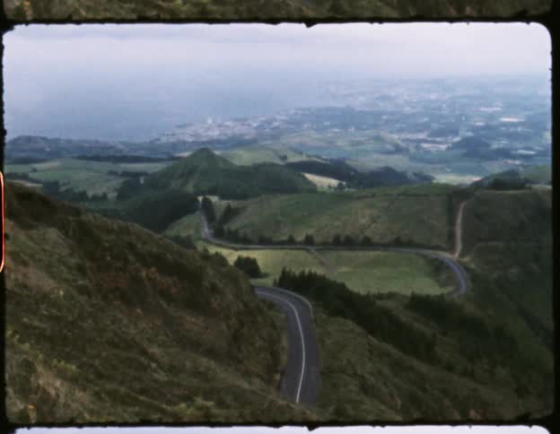 Landscape of hills a paved road and small town in daylight