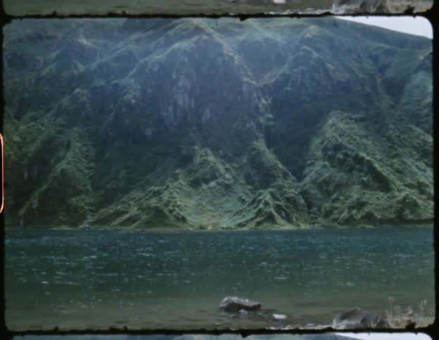 Film of the calm waters of a lake near the mountains